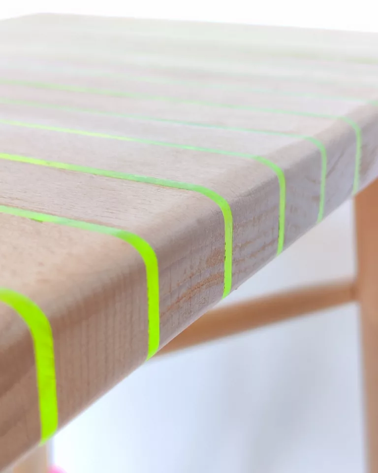 Détail de l'assise en mille-feuille hêtre et plexiglass fluorescent du tabouret VIF, Atelier Popi